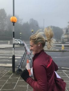 A lady running in a maroon coloured jacket