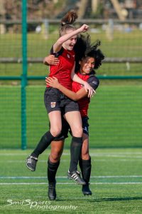 Two girls celebrating football success.